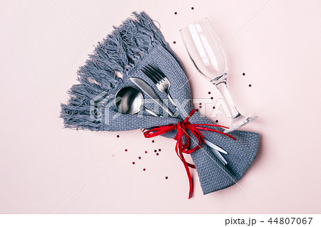 Champagne glass, cutlery and napkin on pink pastel background. Christmas Table Setting 44807067