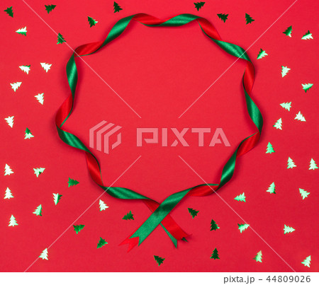 Christmas wavy ribbon round frame on red background. 44809026