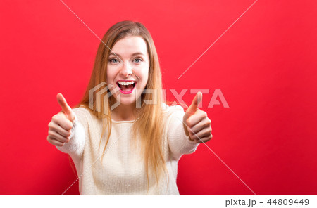 Happy young woman giving thumbs up Happy young woman giving thumbs up 44809449