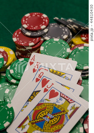 Casino chips and poker cards on green table 44810430
