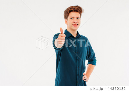 Attractive smiling boy student showing thumbs up Attractive smiling boy student showing thumbs up 44820182