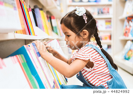 asian girl select book on bookshelf in bookstore asian girl select book on bookshelf in bookstore 44824992