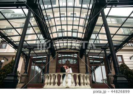 Couple stand near big building in their wedding day 44826899