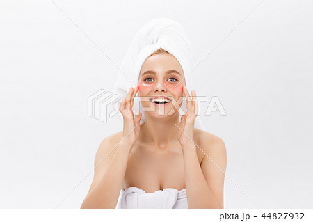 Close up of a young woman with patches under eyes from wrinkles and dark circles. Isolated on white Close up of a young woman with patches under eyes from wrinkles and dark circles. Isolated on white 44827932