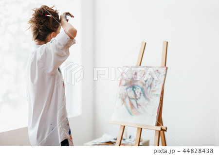 Artist tired after drawing, wipes forehead 44828438