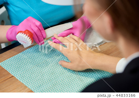 Female customer receiving professional manicure in beauty salon.  44833166