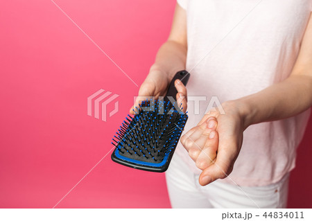 Beautiful young sad woman showing comb Beautiful young sad woman showing comb 44834011