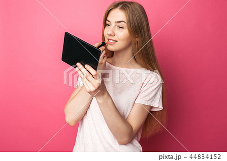 A young girl paints lips with lipstick A young girl paints lips with lipstick 44834152