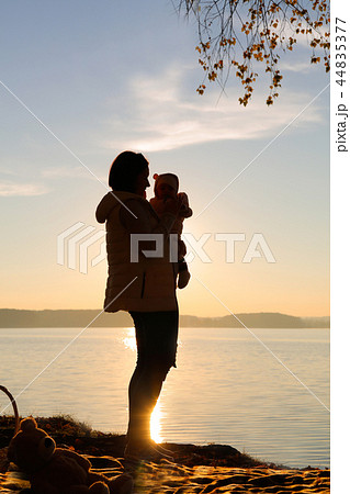 A mother and her child playing in the autumn on the seashore A mother and her child playing in the autumn on the seashore 44835377