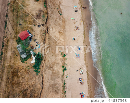 People rest on the wild beach with their families. 44837548