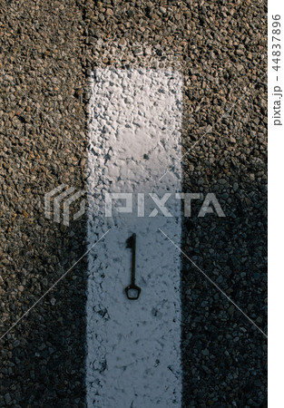 Old vintage brass door Key on asphalt road 44837896