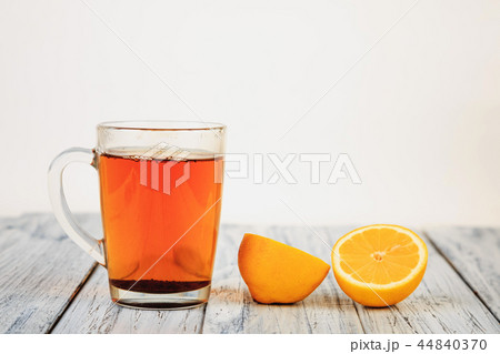 tea and lemon halves on wooden table 44840370