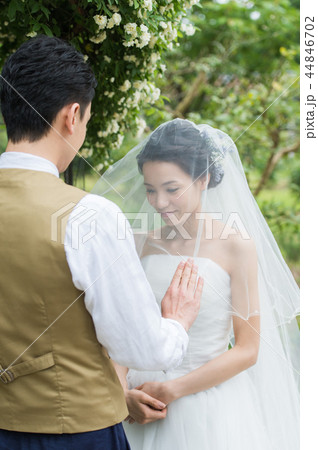 ガーデンウエディングでベールアップをする新郎新婦 44846702