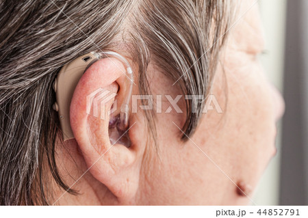 Closeup senior woman using hearing aid 44852791
