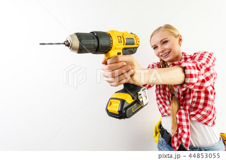 Woman using drill on wall Woman using drill on wall 44853055