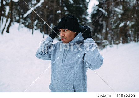 Sportsman standing in winter forest holding a hood Sportsman standing in winter forest holding a hood 44855358