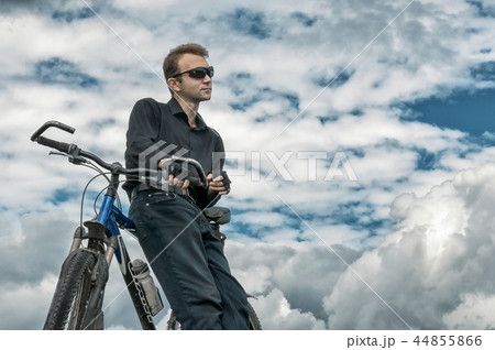 Man stay with bicycle in nature blue sky Man stay with bicycle in nature blue sky 44855866
