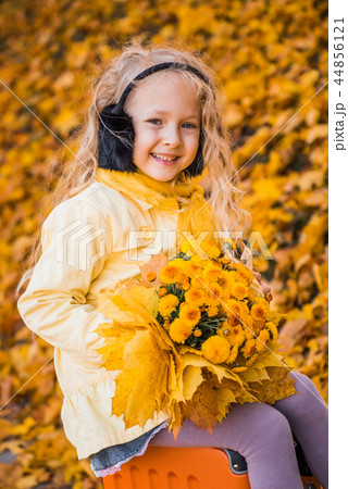 Little beautiful girl with blond hair in autumn background 44856121
