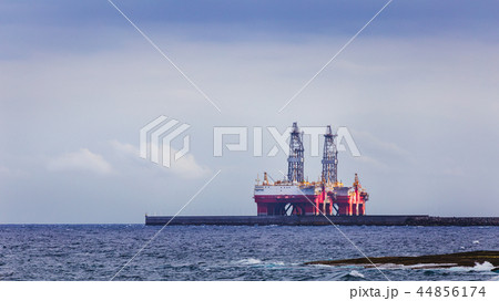 Two masts of oil rig on sea near coastline. Two masts of oil rig on sea near coastline. 44856174