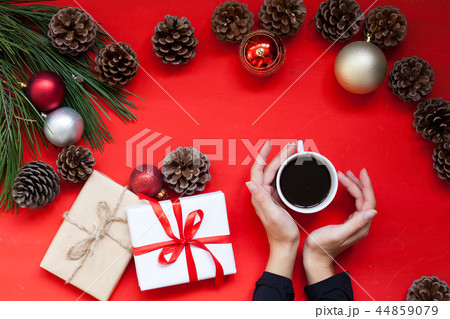 Christmas tree needles Cup of tea in the hands of the Red Christmas background Christmas 44859079