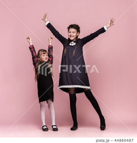 Cute stylish children on pink studio background. The beautiful teen girls standing together 44860487