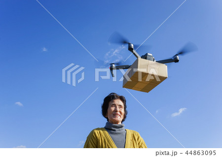 ドローンで荷物を受け取るシニア女性 44863095