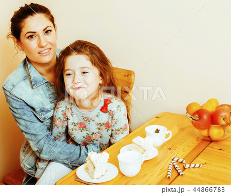 young mother with daughter on kitchen drinking tea together hugg 44866783