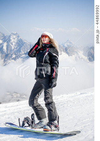 Young adult woman snowboarder holding snow board 44869992