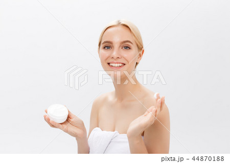 Close up beauty portrait of a laughing beautiful half naked woman applying face cream and looking 44870188