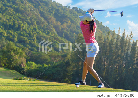 Asian woman golf player doing golf swing tee off  44875680