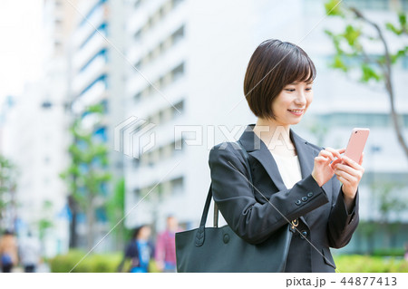 オフィス街 スマホを持ったスーツの女性 OL ビジネス スーツ ポートレート リクルート オフィス街 スマホを持ったスーツの女性 OL ビジネス スーツ ポートレート リクルート 44877413