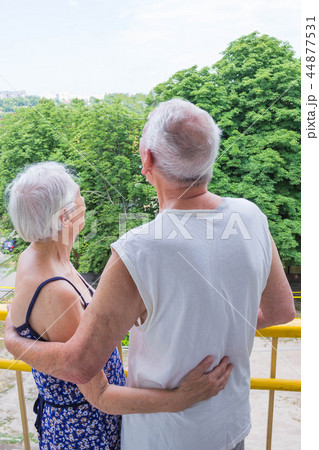 Senior couple standing oustide at balccony at home and looking away Senior couple standing oustide at balccony at home and looking away 44877531