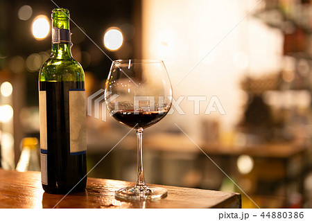 Bottle and glass of red wine on wooden top 44880386