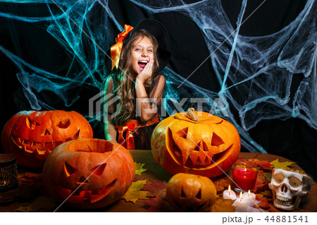 Halloween concept - little witch child enjoy playing with magic wand over spider web and with curved 44881541
