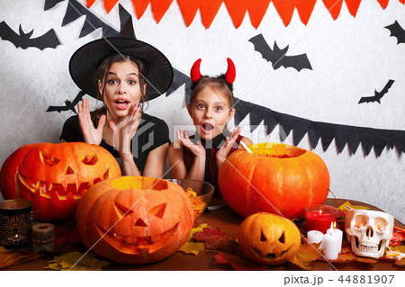 Funny Mother and daughter having fun at home. Happy family preparing for Halloween. People wearing 44881907