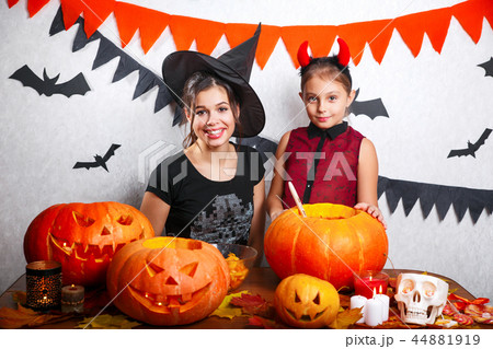 Happy Halloween. Mother and daughter carving pumpkin. Family preparing for holiday. Happy Halloween. Mother and daughter carving pumpkin. Family preparing for holiday. 44881919