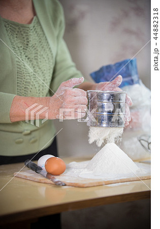 An old lady making little pies. Sift flour An old lady making little pies. Sift flour 44882318