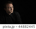 young man close up portrait, on black with glasses 44882445