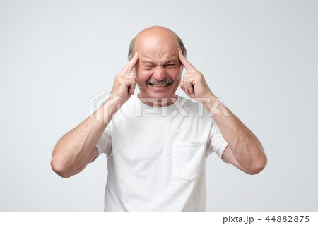 man holds fingers on temples, has bad memory man holds fingers on temples, has bad memory 44882875