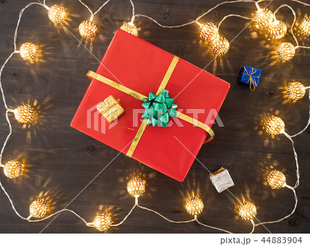 Christmas gift box on wooden background with small presents and Christmas light. Christmas gift box on wooden background with small presents and Christmas light. 44883904