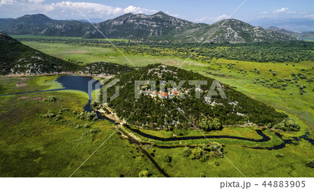 Aerial view of the landscape of Lake Skadar in the mountain and the island with monastery on a Aerial view of the landscape of Lake Skadar in the mountain and the island with monastery on a 44883905