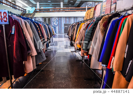 Coats and jackets on hangers in the store. Sale of outerwear. 44887141