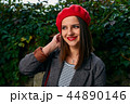 Fixing hair under red beret. 44890146