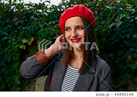 Fixing hair under red beret. Fixing hair under red beret. 44890146