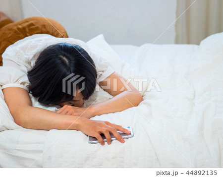 ベッドで眠る若い女性 44892135