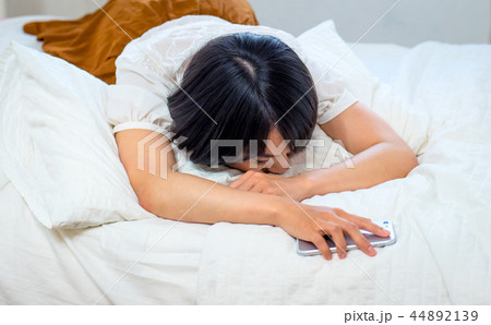 ベッドで眠る若い女性 44892139