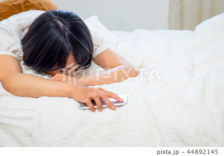 ベッドで眠る若い女性 44892145