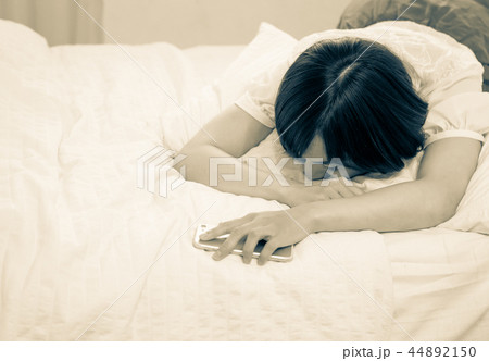 ベッドで眠る若い女性 44892150