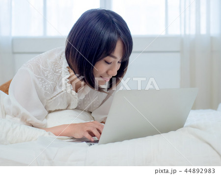 ベッドでパソコンを操作する女性 44892983