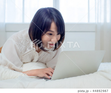 ベッドでパソコンを操作する女性 44892987